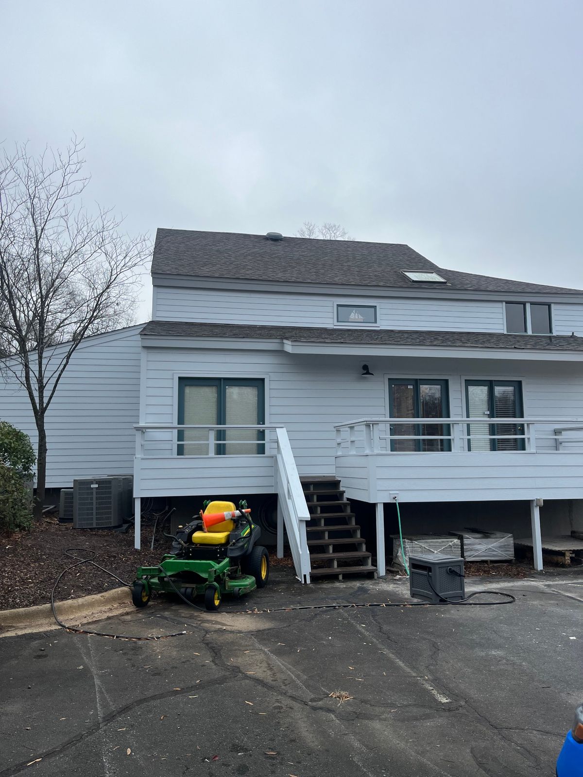 Same home finished with new white lap siding, painted trim and refreshed deck railings