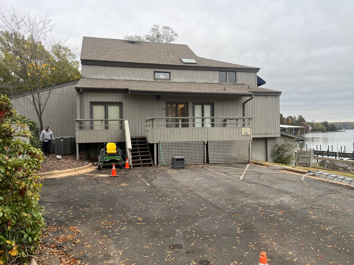 Lakeside home with worn gray vertical wood siding before the project